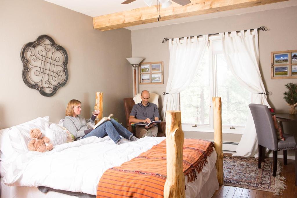 eine Familie auf einem Bett in einem Schlafzimmer in der Unterkunft Pueblo Canyon Inn in Los Alamos