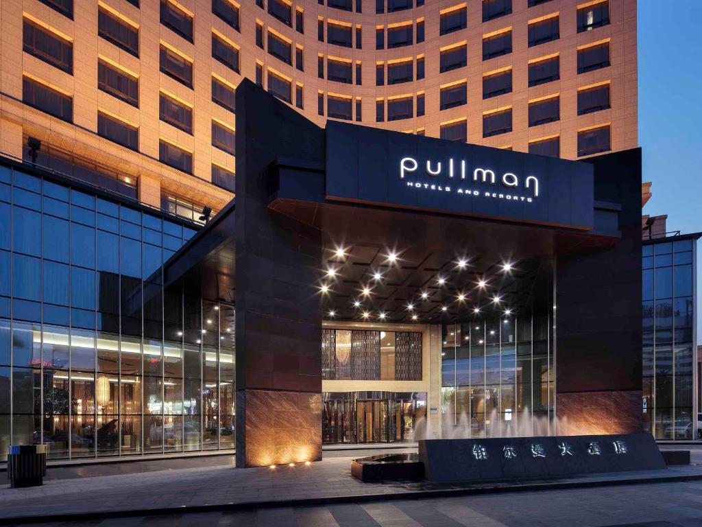 a building with a sign on the front of it at Pullman Anshan Time Square in Anshan