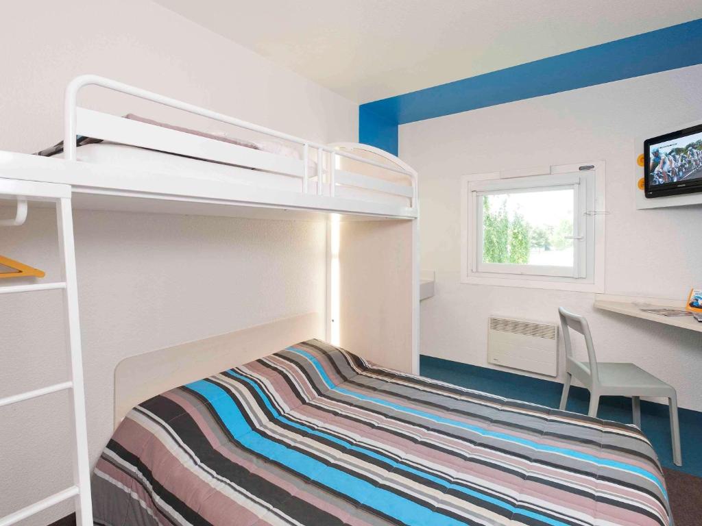 ein kleines Schlafzimmer mit einem Etagenbett und einem Schreibtisch in der Unterkunft hotelF1 Saint Brieuc in Tregueux