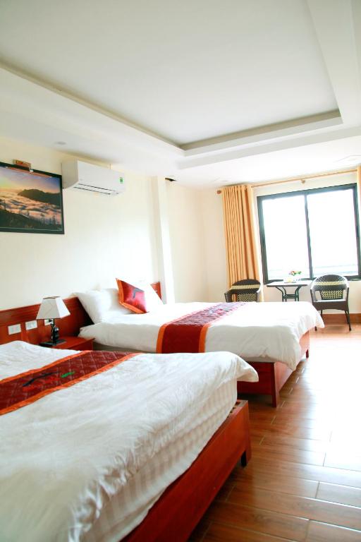 a hotel room with two beds and a window at Son Ha Hotel SAPA in Sapa