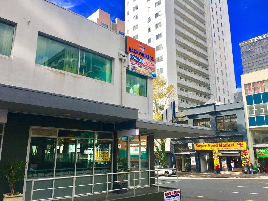 a building on a city street with tall buildings at Metro Adventurer Backpackers in Auckland