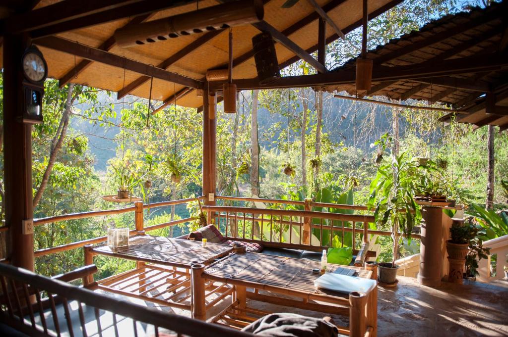 a porch with a table and a view of the forest at Hot Coffee Guest House and Resort in Ban Mae Na Chon
