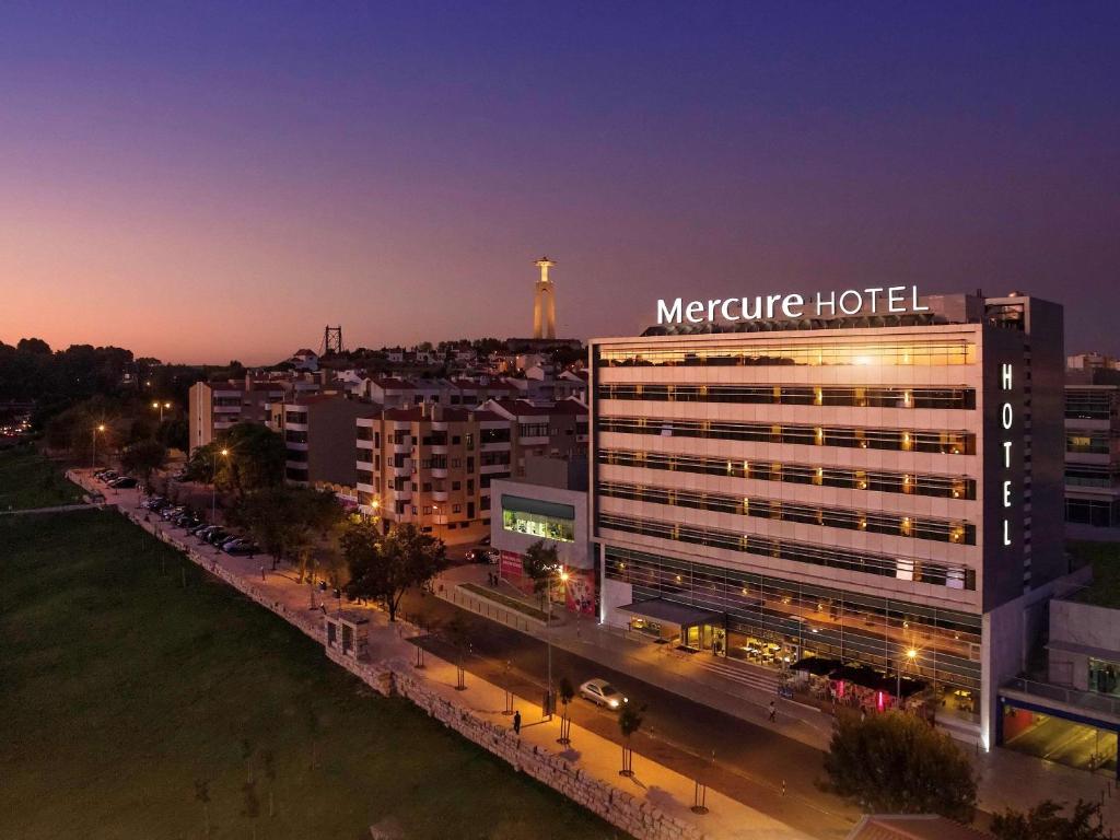 a night view of a hotel in a city at Mercure Lisboa Almada in Almada
