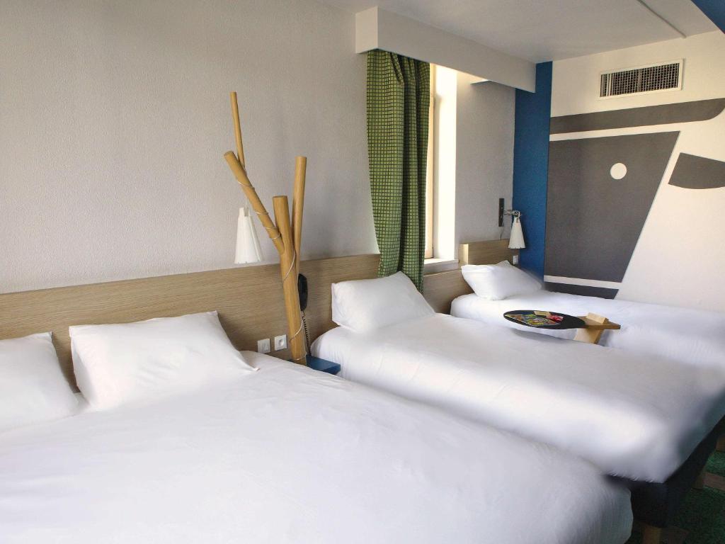 a hotel room with two beds and two lamps at ibis Styles Moulins Centre in Moulins