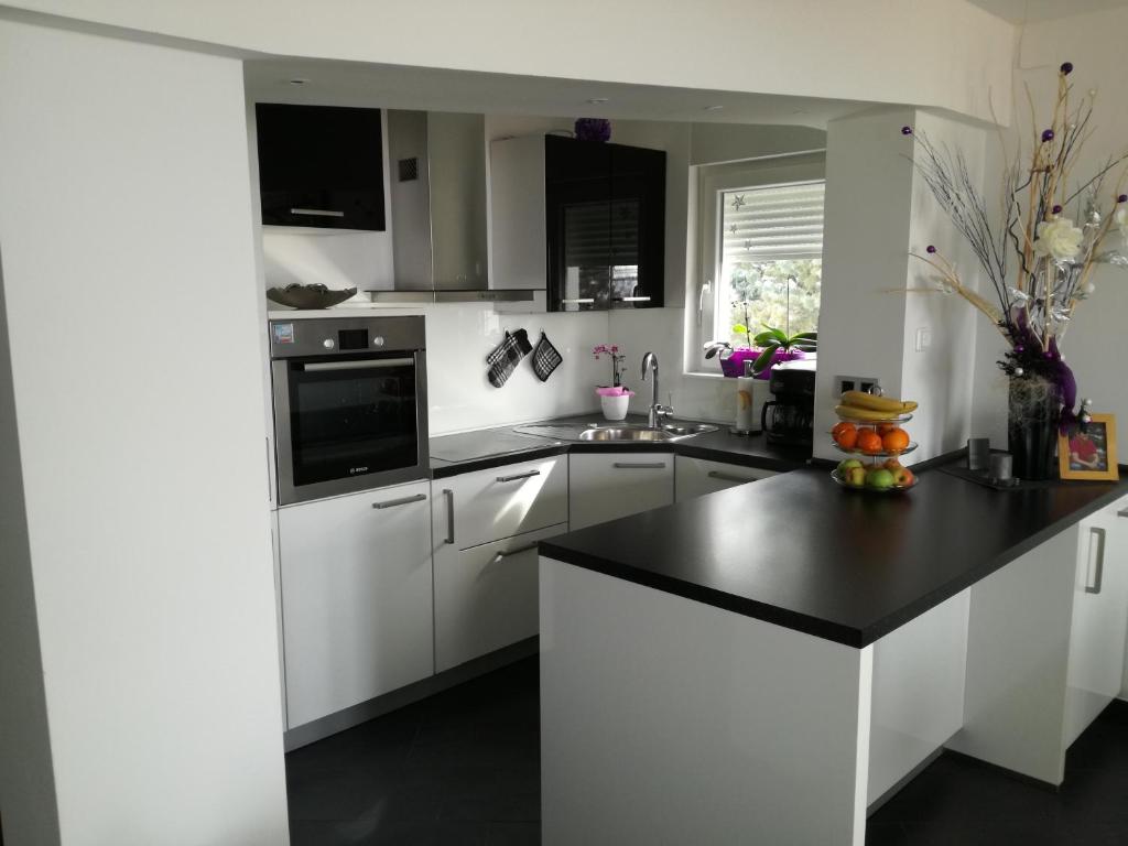 a kitchen with white cabinets and a black counter top at Apartment Andro in Dramalj
