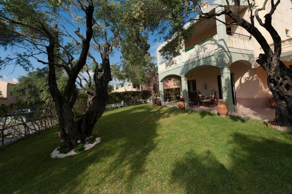 una casa con un patio verde con un árbol en Barbati Pietre Di Mare, en Barbati