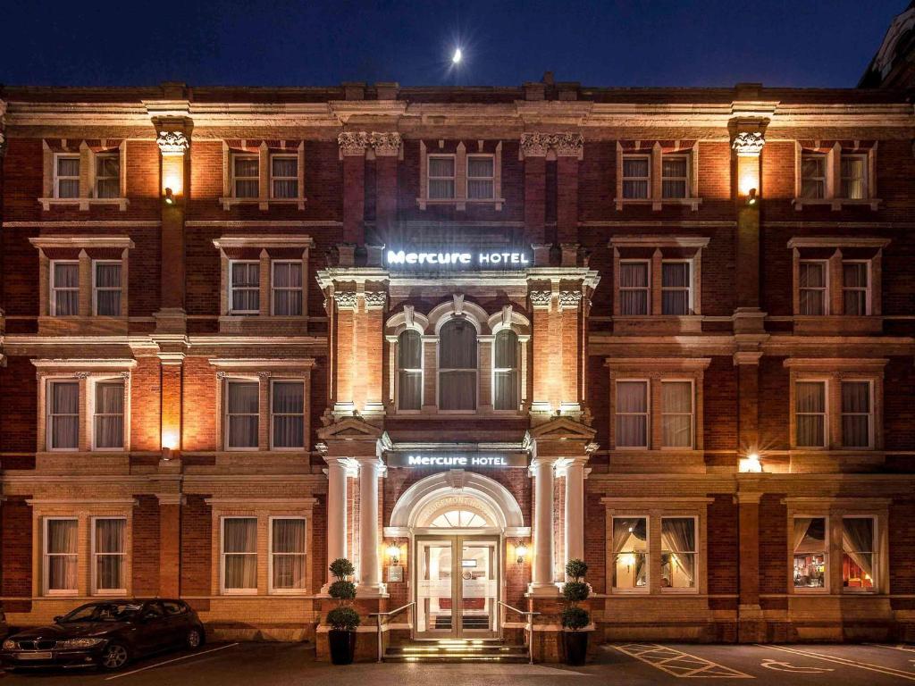 een gebouw met de voordeur verlicht in de nacht bij Mercure Exeter Rougemont Hotel in Exeter