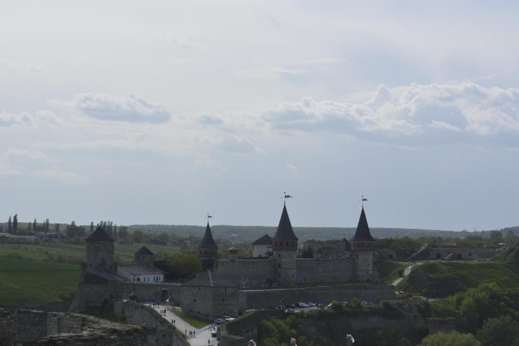 an old castle with snowy mountains in the background at Apartment Vid na Krepost in Kamianets-Podilskyi