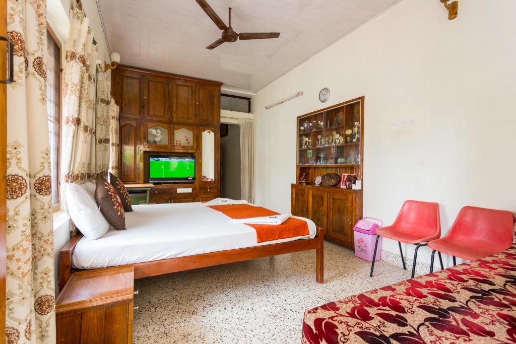 a bedroom with a bed and a flat screen tv at Thoms Beach Homestay in Alleppey