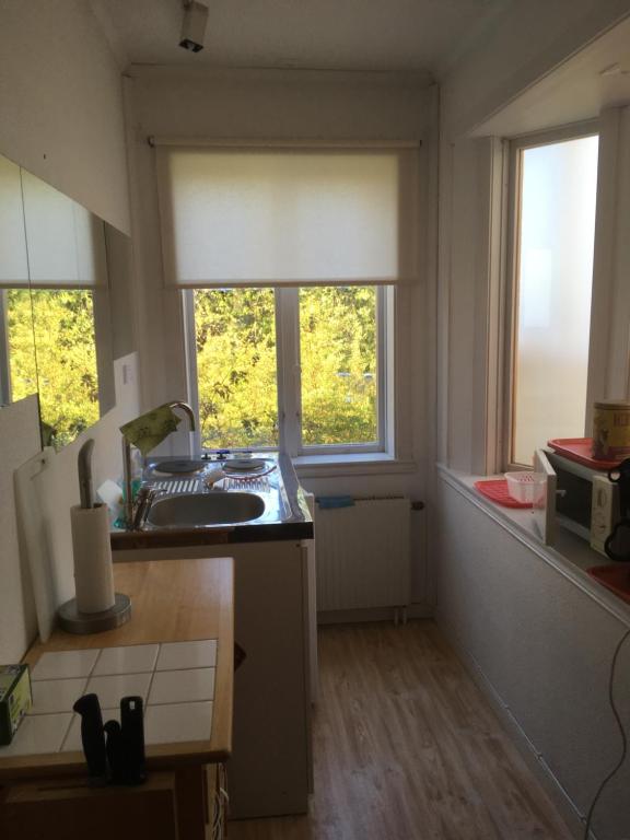 a kitchen with a sink and two windows in it at Borgholm Rum Centralt in Borgholm