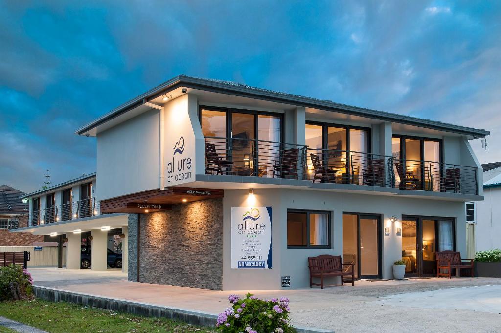 a building with a sign in front of it at Allure On Ocean Motel in Mollymook