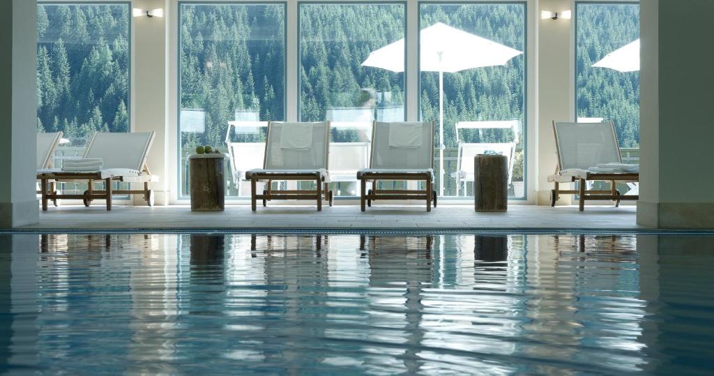una stanza con sedie e una piscina d'acqua di Stern B&B & Suite Apartments a Nova Levante