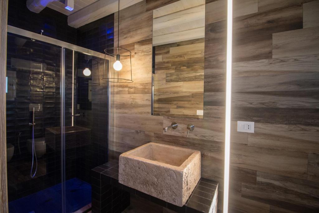a bathroom with a stone sink and a shower at Casa Martina in Monopoli