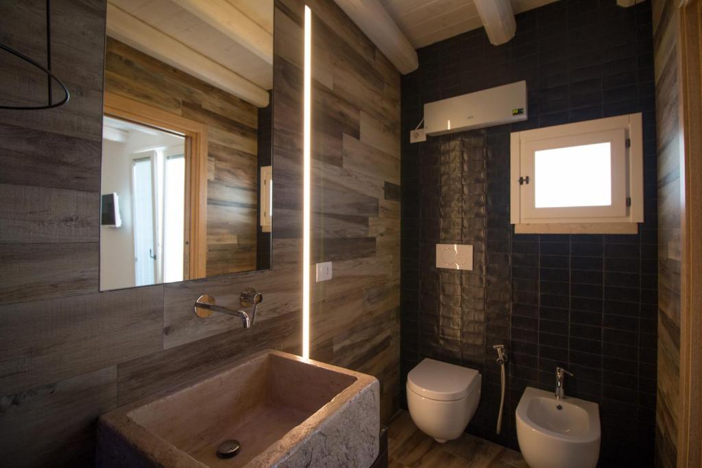 a bathroom with a sink and a toilet and a mirror at Casa Martina in Monopoli