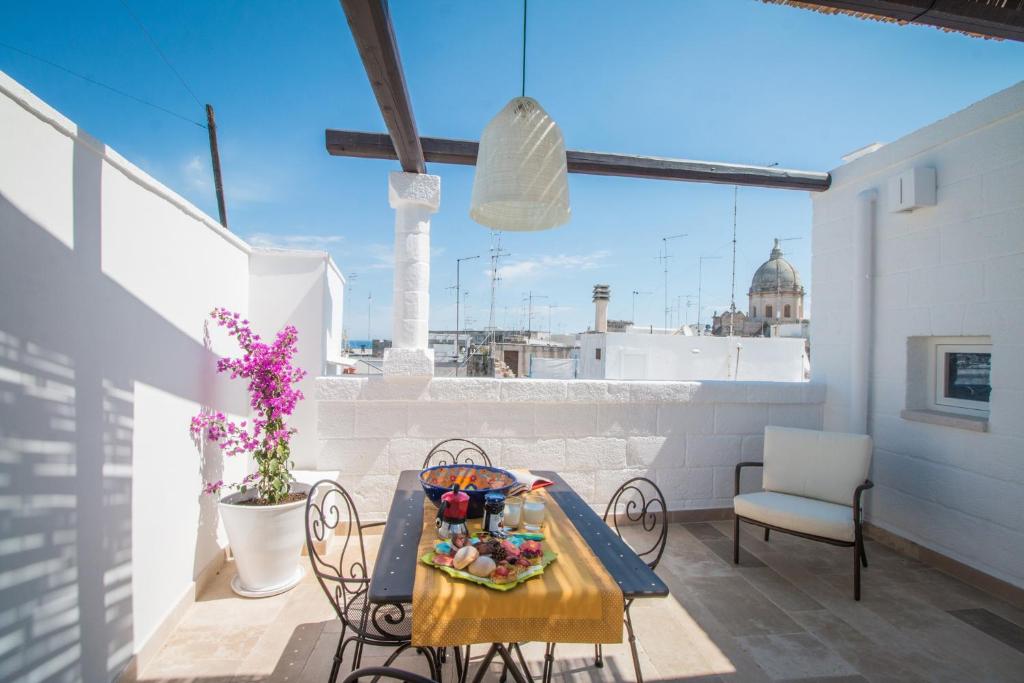 een tafel en stoelen op een balkon met uitzicht op de stad bij Casa Martina in Monopoli