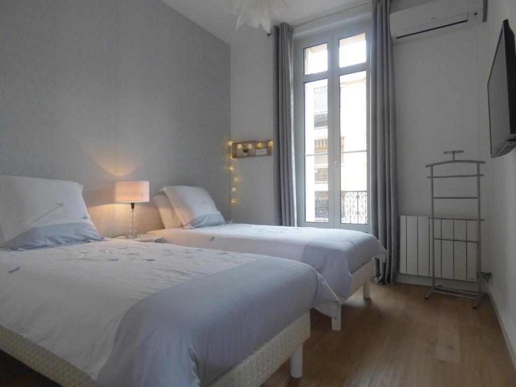 - une chambre avec 2 lits et une fenêtre dans l'établissement Happy days, by Welcome to Cannes, à Cannes