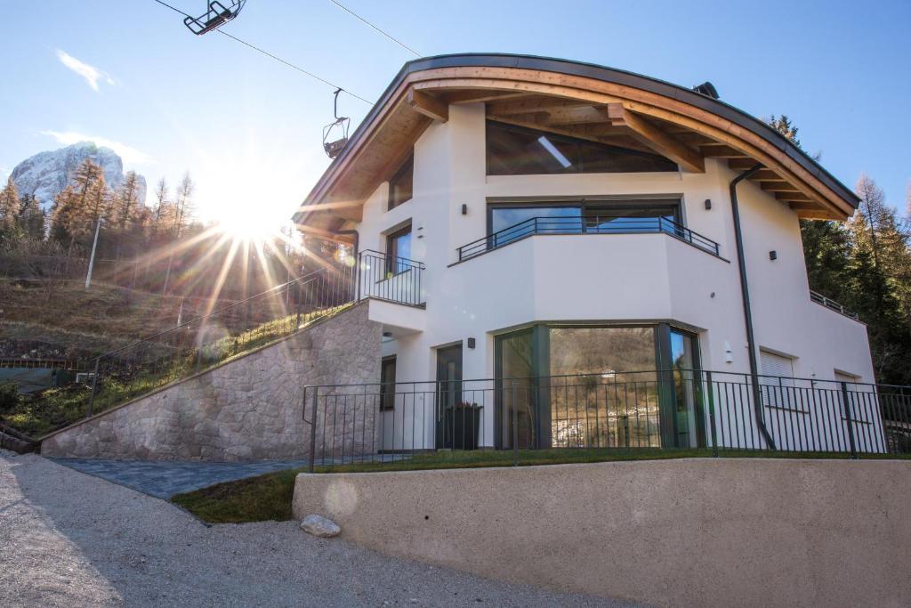 een huis op een heuvel met de zon erachter bij Arpa Chalet in Santa Cristina in Val Gardena