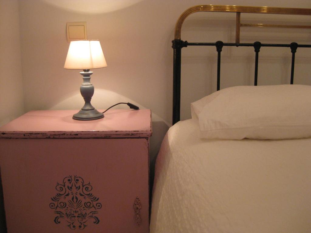 a lamp sitting on a box next to a bed at Apartamentos Puenteviejo in Arenas de San Pedro