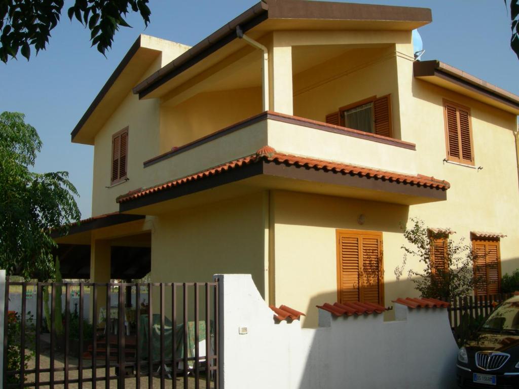 a house with a fence in front of it at Villa Magnolia Appartamenti in Nicotera Marina