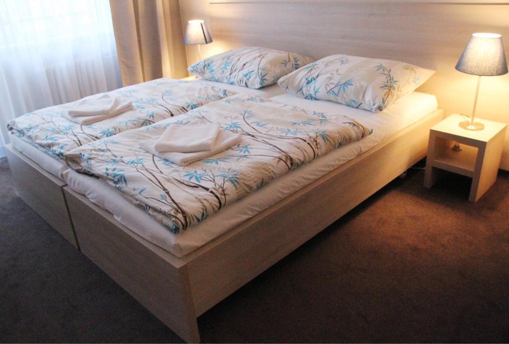 Cama en habitación con lámpara y almohadas en Hotel SPECTRUM en Trnava