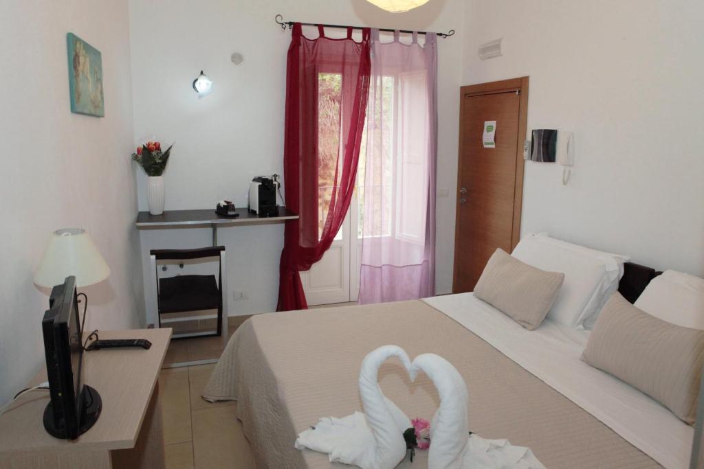 a bedroom with a bed with two white swans on it at La Corte Di Ibla in Ragusa