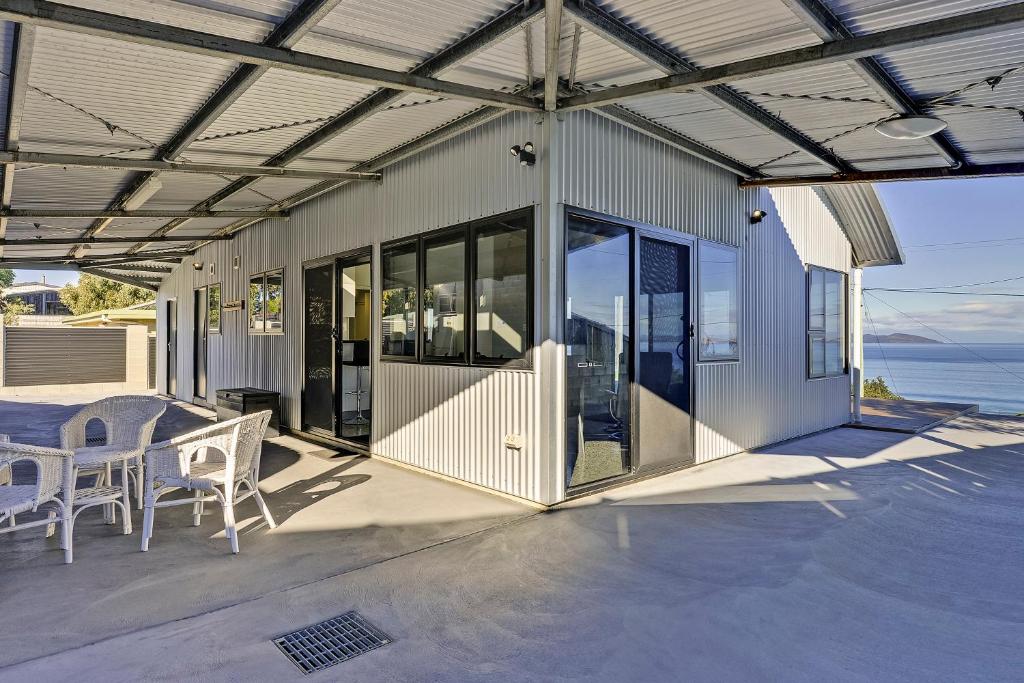 a house with a patio with a table and chairs at Park Beach Retreat in Dodges Ferry