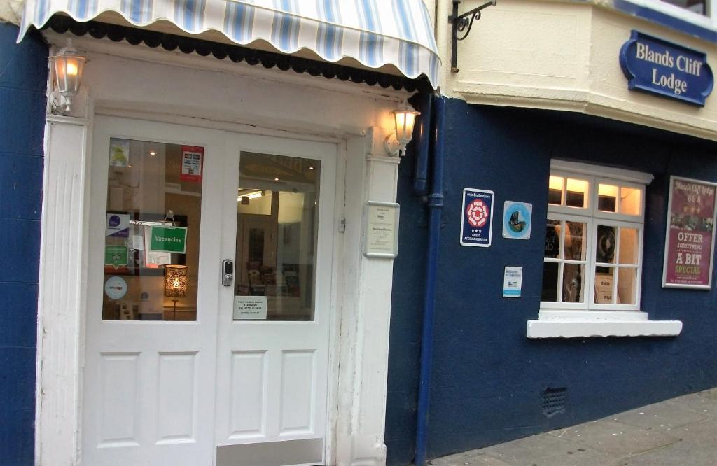 a blue building with a white door on a street at Blands Cliff Lodge in Scarborough