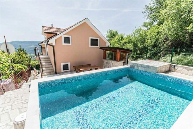 a swimming pool in front of a house at Vila Loza in Herceg-Novi