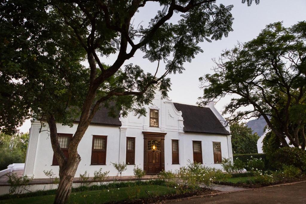 a white house with a black roof at Vrede en Lust Estate in Simondium