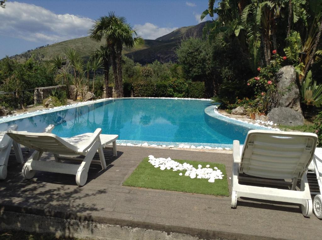 - une piscine avec 2 chaises longues et une table dans l'établissement Piccolo Paradiso, à Formia