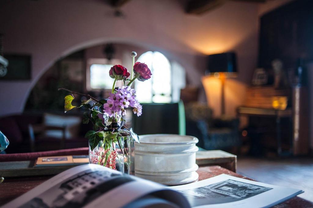 un jarrón de flores en una mesa con un libro en Villa La Lodola, en Foiano della Chiana