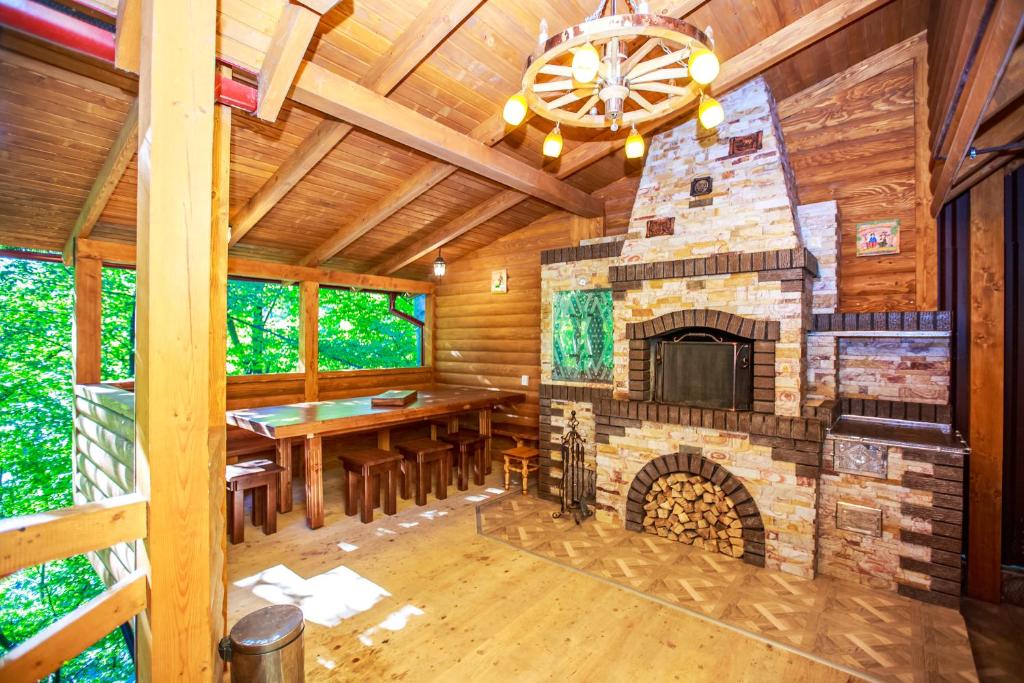 a dining room with a stone fireplace in a log cabin at Cottage Berdo in Yaremche