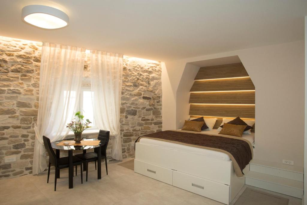 a bedroom with a bed and a table and a window at Situs Residence in Split