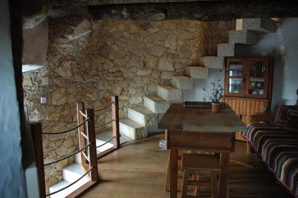 リオ・マイオルにあるMoinho do Avo Toの石壁の客室で、テーブルと椅子が備わります。