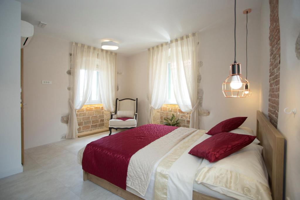 a bedroom with a large bed with red pillows at Situs Residence in Split