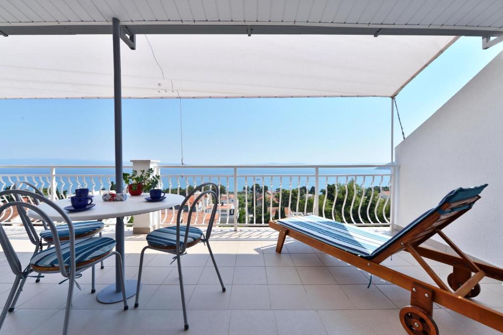 a balcony with a table and chairs and the ocean at Apartment ANGIE - Marjan Hill in Split