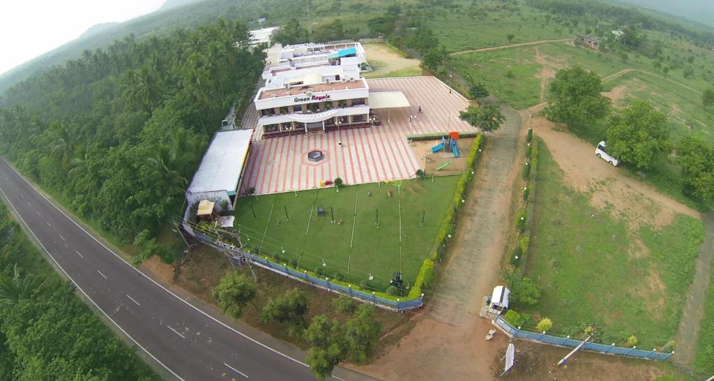 Vue aérienne d'une maison sur une colline à côté d'une route dans l'établissement Green Royale Resorts, à Bodināyakkanūr
