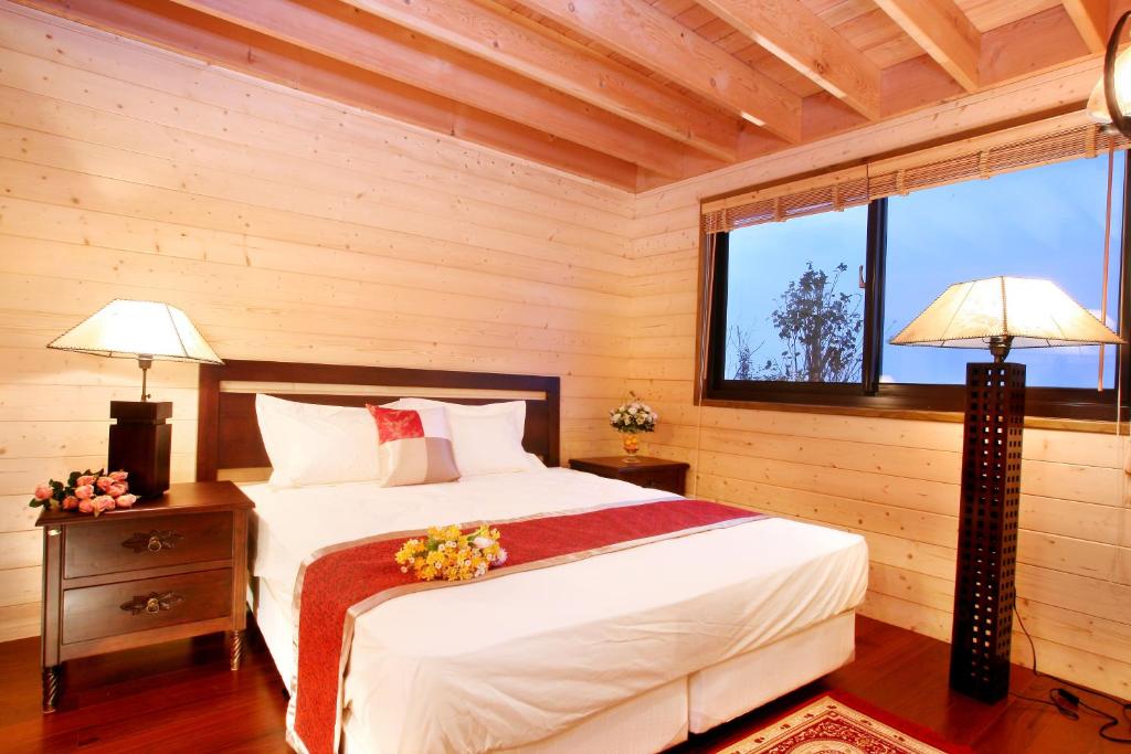 五結鄉的住宿－大好親水河畔民宿，一间卧室配有一张床、两盏灯和一个窗户。