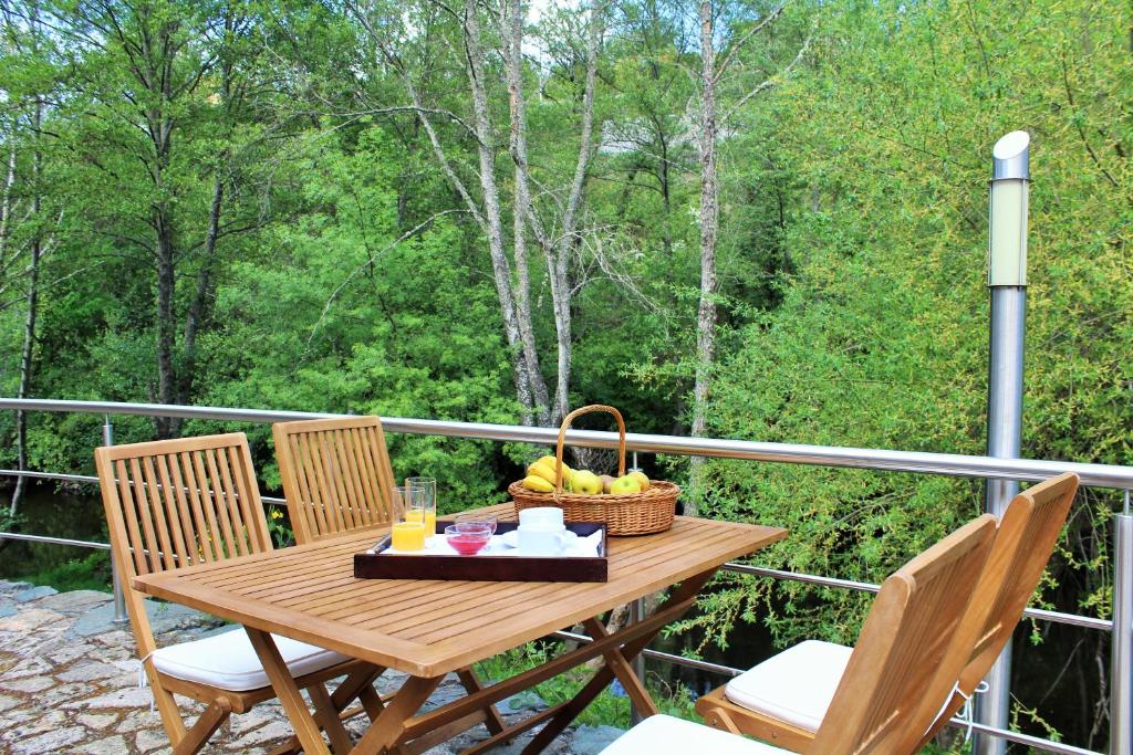a wooden table with a basket of fruit on a balcony at Moinho da Ponte Velha in Bragança