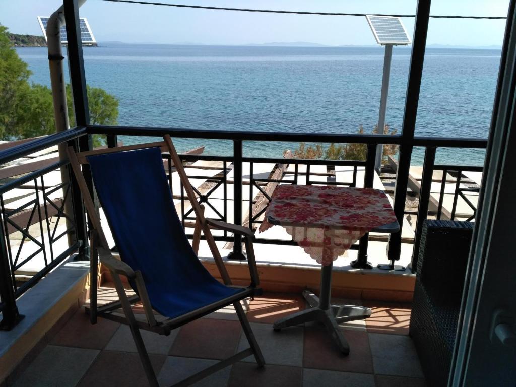 a balcony with chairs and a table and the ocean at 9 Musses Studios in Skala Mistegnon