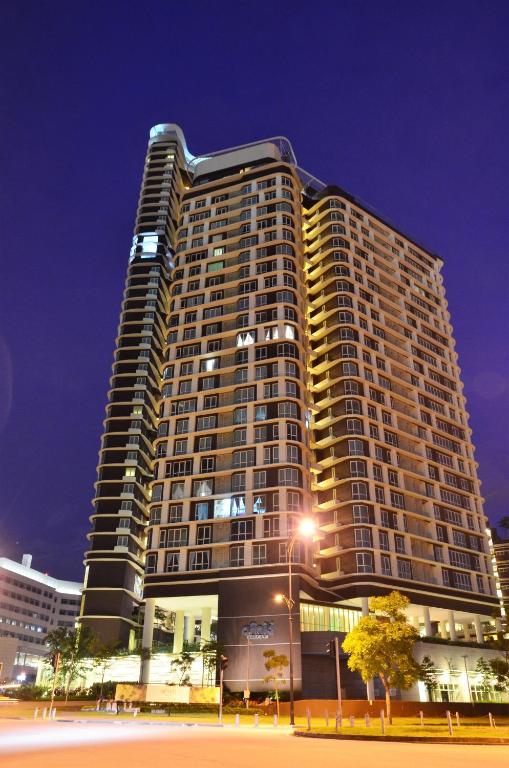 a tall building at night with a street at Holi Afiniti Themed Suites in Nusajaya
