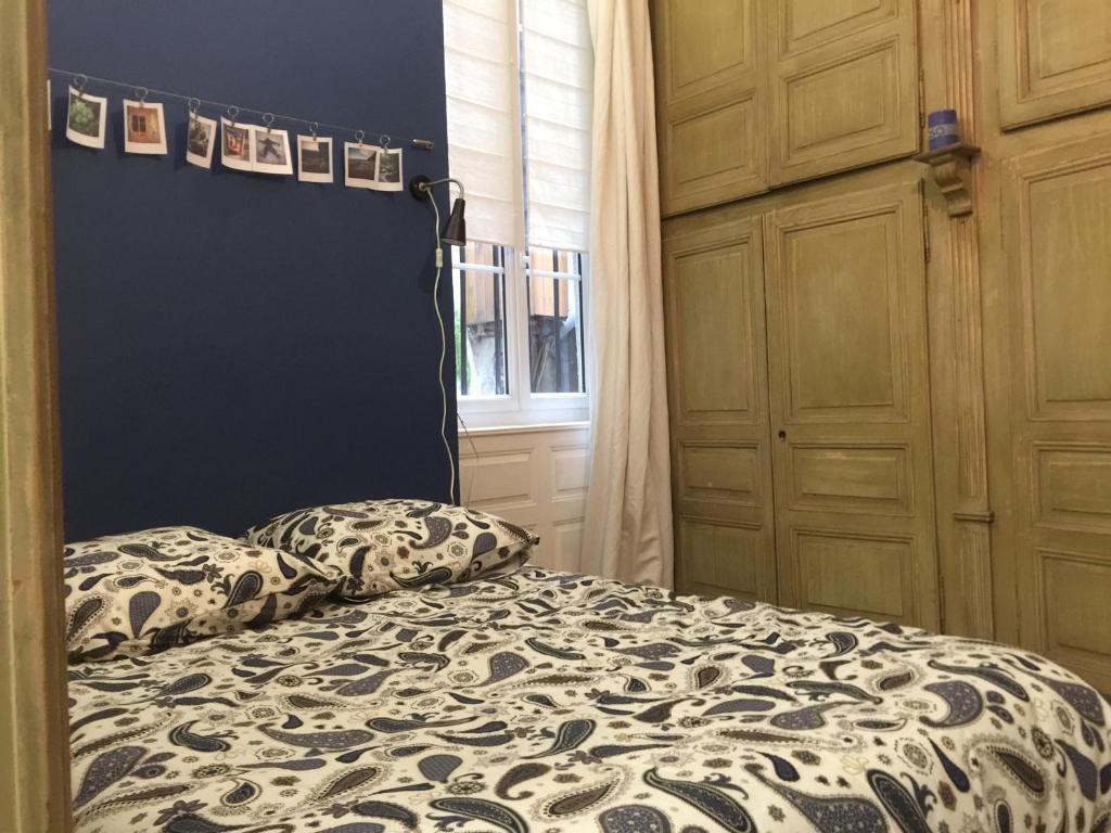 オーリヤックにあるle bal d'arsèneのベッドルーム1室(ベッド1台付)、壁に絵が飾られています。