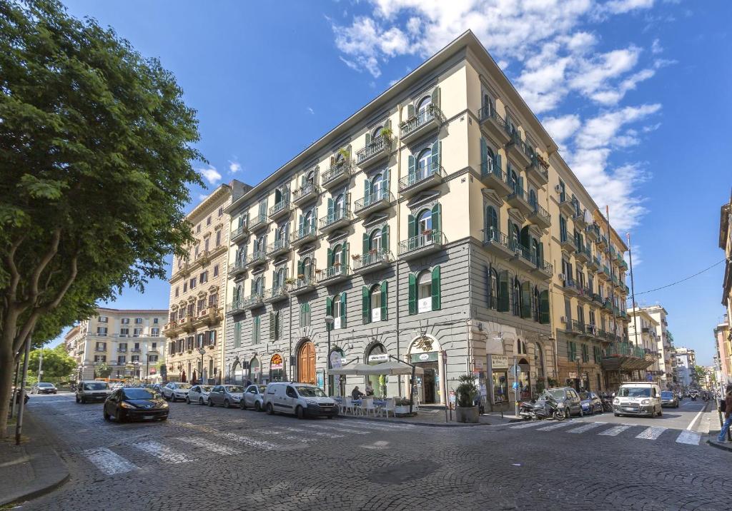 un grande edificio con macchine parcheggiate di fronte di Certosa Suite a Napoli