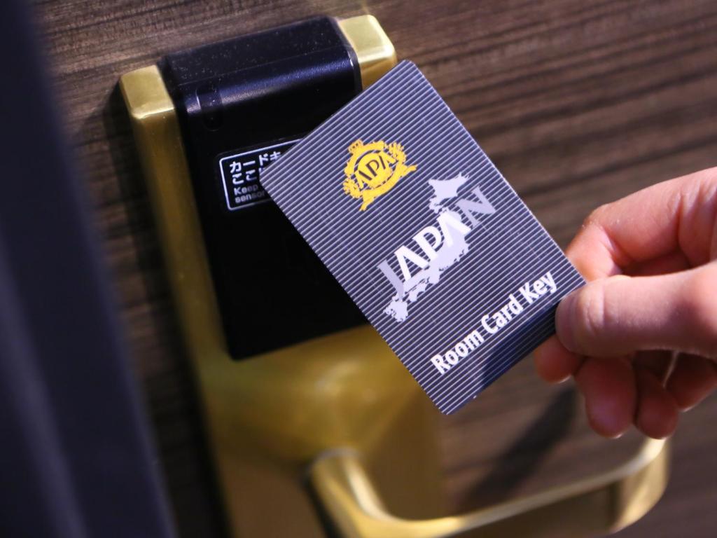 a person holding a purple tag on a camera at APA Hotel Ningyocho Ekikita in Tokyo