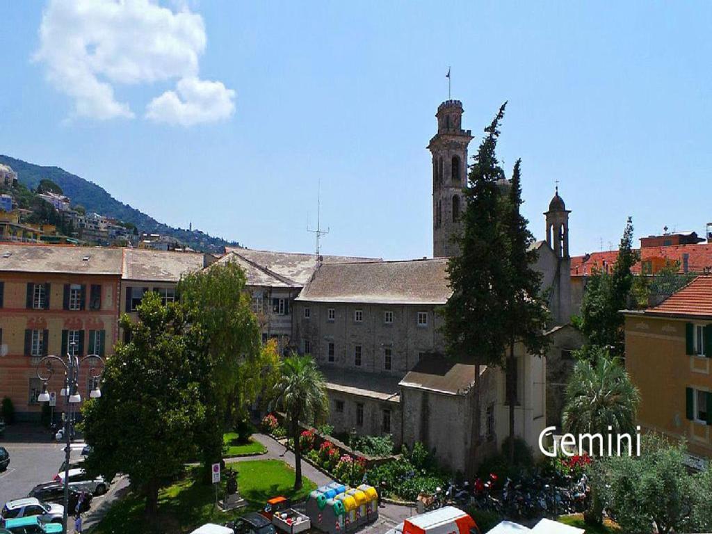 un antiguo edificio con una torre de reloj en una ciudad en Libra Flexyrent en Rapallo