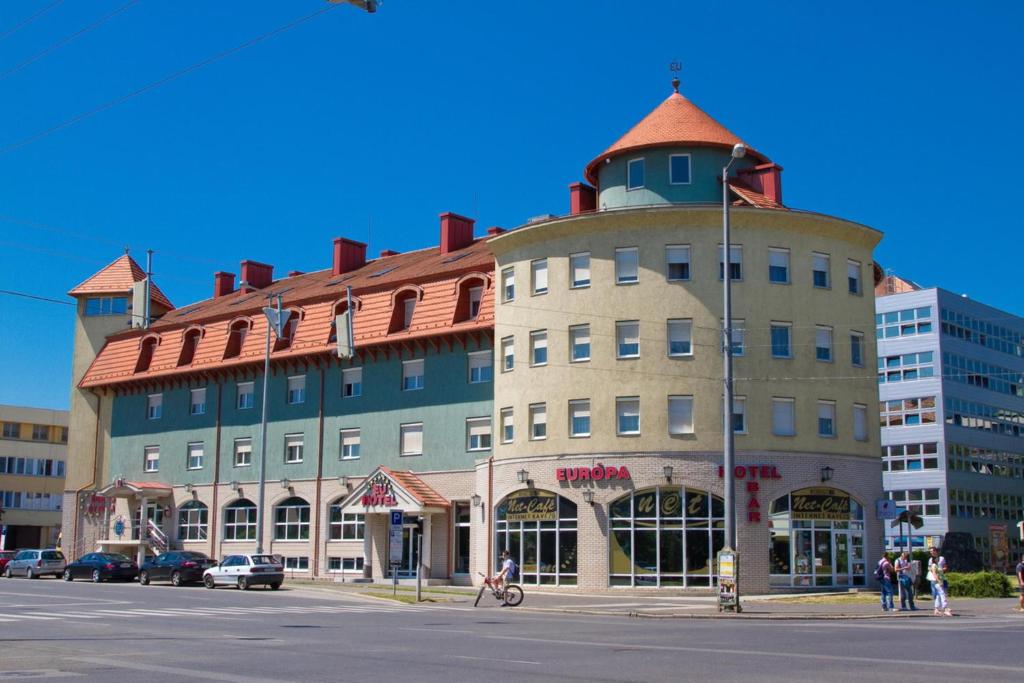een groot gebouw op de hoek van een straat bij Europa Hotel És Étterem in Nyíregyháza