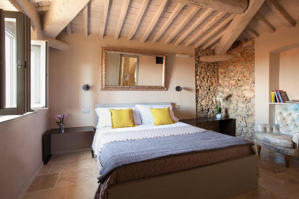 カスタニェート・カルドゥッチにあるCamere di Via Montebelloのベッドルーム1室(黄色い枕と鏡付きのベッド1台付)