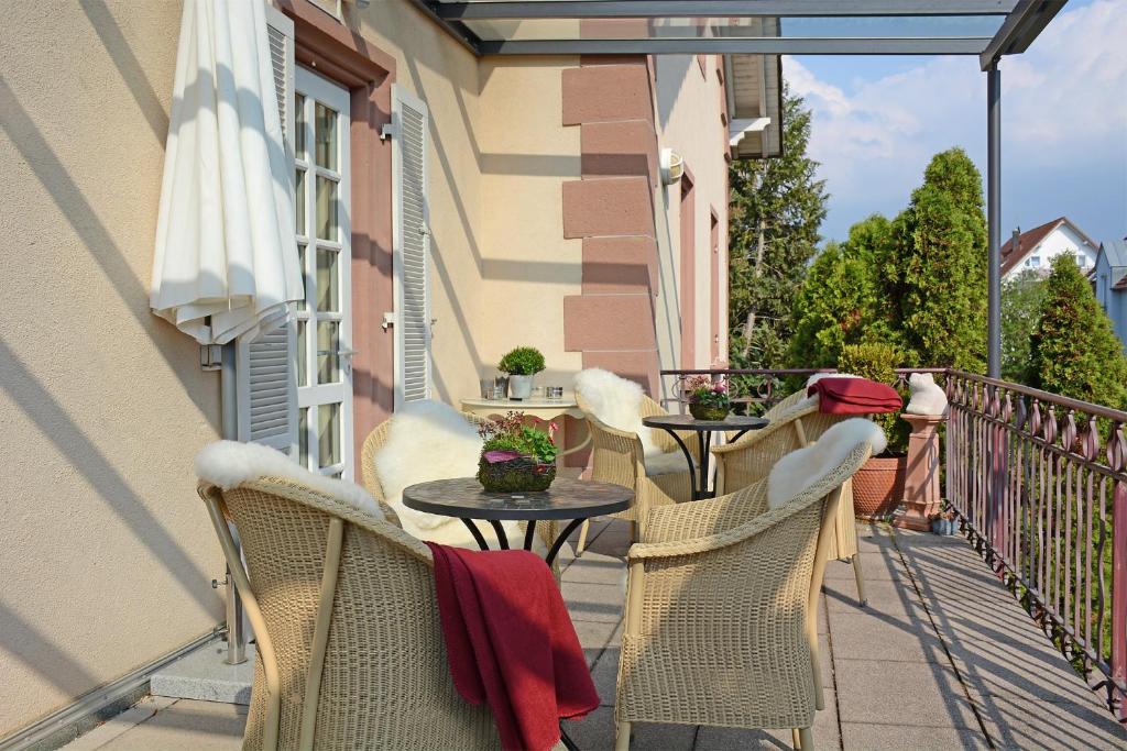 einen Balkon mit Tischen und Stühlen auf einem Gebäude in der Unterkunft Hotel garni Kaiserstuhl in Ihringen