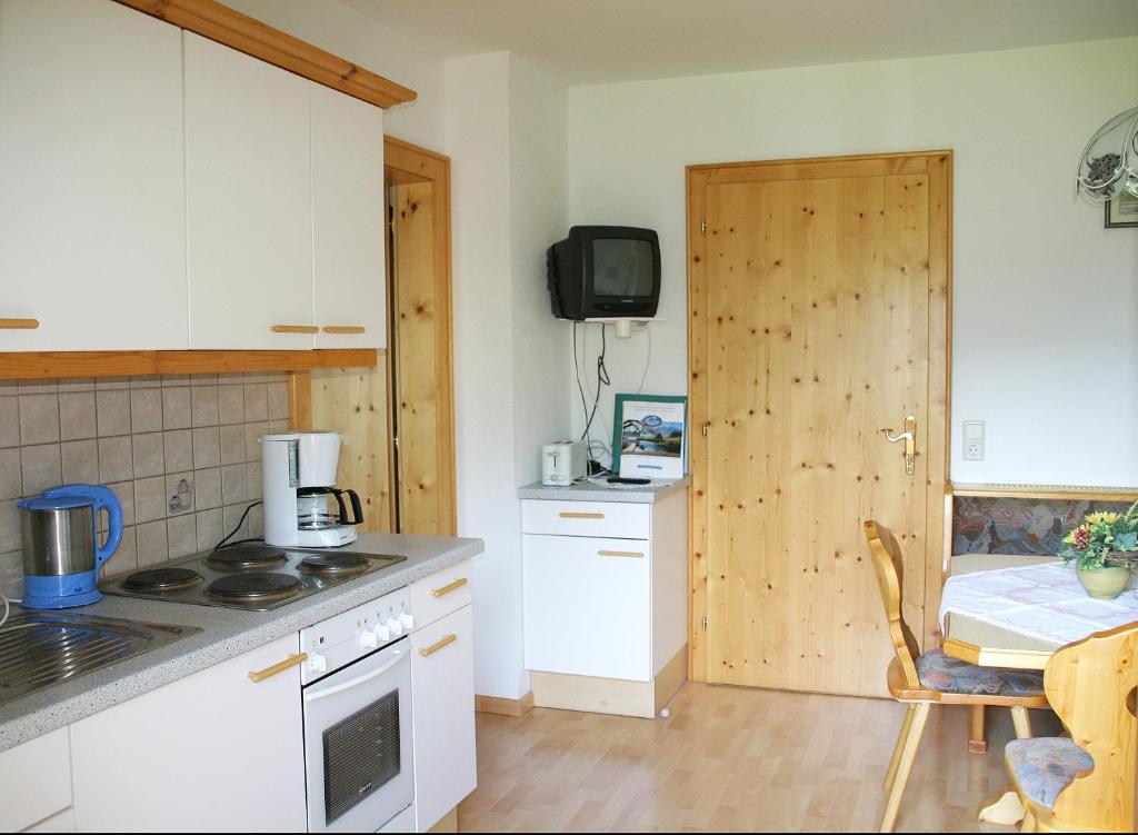 eine Küche mit weißen Geräten und einer Holztür in der Unterkunft Edthof in Lungötz
