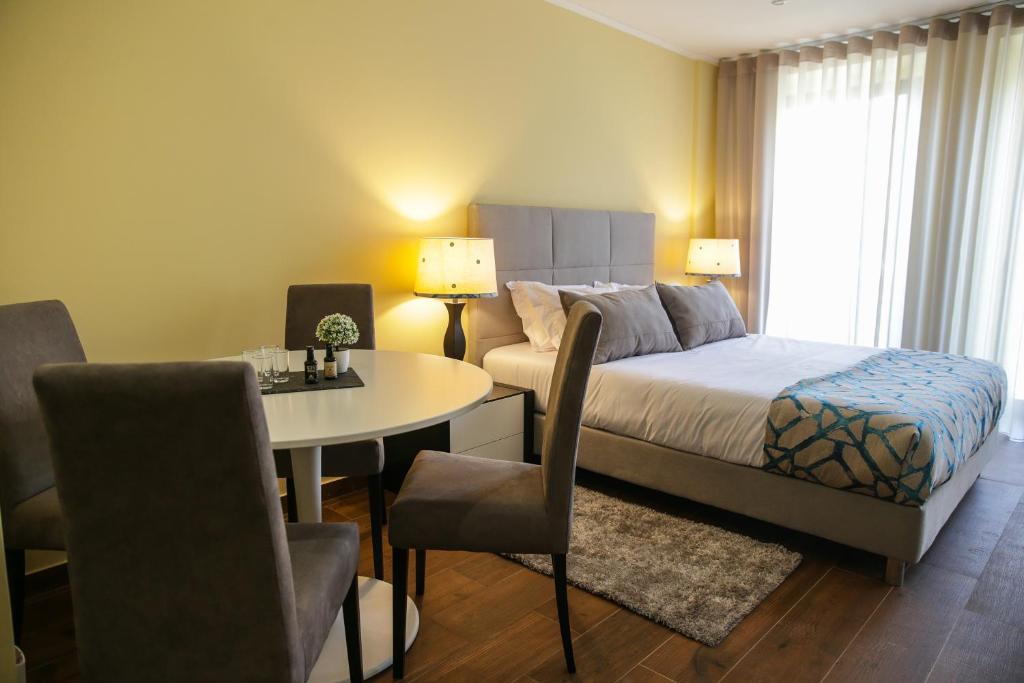 een slaapkamer met een bed en een tafel en stoelen bij Oporto Downtown Flats in Porto
